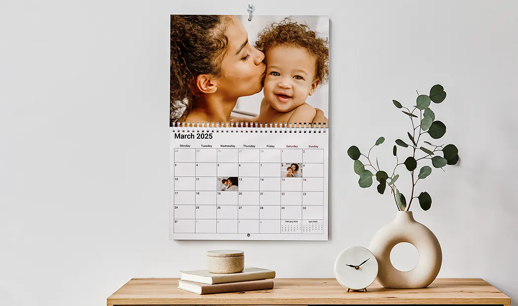 Gepersonaliseerde wandkalender 2020 van Printerpix|Gepersonaliseerde Fotokalenders|Vrouw schrijft op A4 gepersonaliseerde wandkalender van printerpix met kerstthema foto|A3 2020 wandkalender opgehangen met gepersonaliseerd fotodesign van printerpix|Romantisch stel in woonkamer met gepersonaliseerde 2020 wandkalender met aanzoekfoto|Hondenfoto's op op maat gemaakte fotokalender aan de muur gehangen