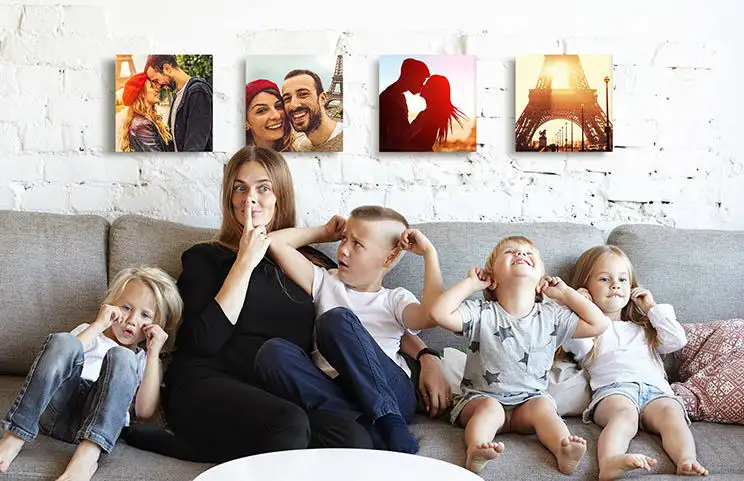 Moeder en vier jonge kinderen zitten op de bank voor vier fotocanvassen